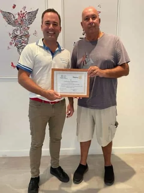 Spine Clinic getting a certificate of recognition from Rotary club of royal Hua Hins president Phil Lawrence.